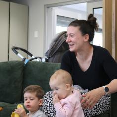 A woman smiling, with her two children